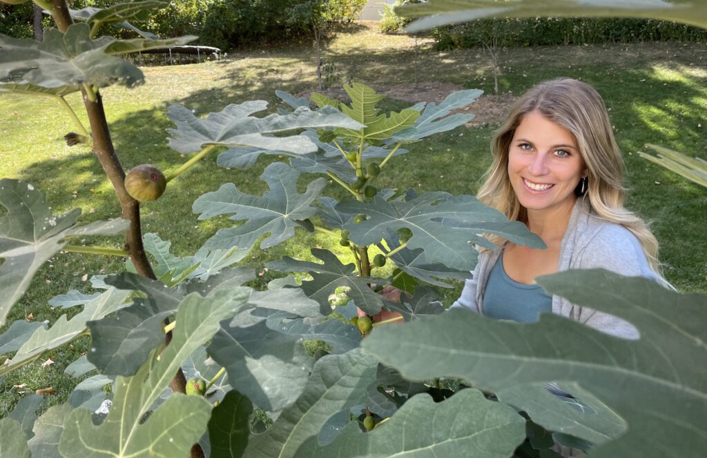 Myriam standing behind a large fig tree