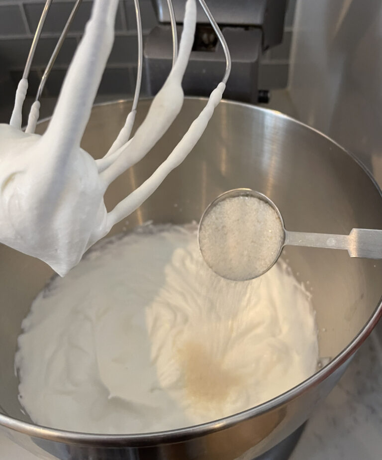 stand mixer whipping heavy cream and a tablespoon of sugar